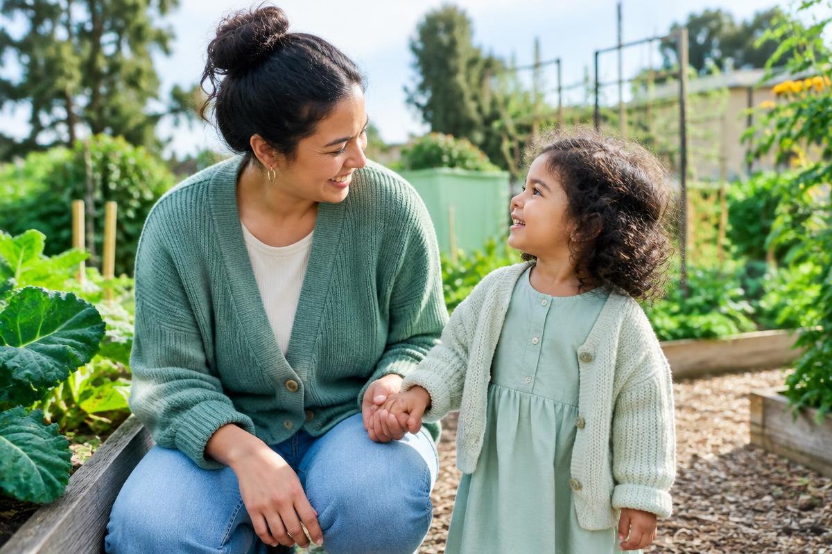 A parent and young child sharing a warm moment in a community garden